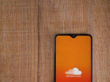 Lod, Israel - 16 Temmuz 2023: SoundCloud uygulama ekranı ahşap zemin üzerinde akıllı telefon. Üst görünüm düzlüğü kopyalama alanı ile yatıyordu.