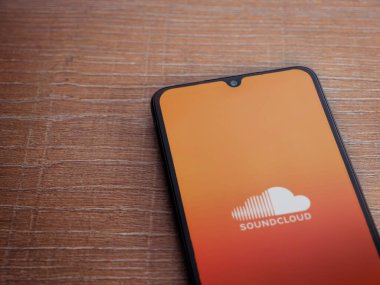Lod, Israel - 16 Temmuz 2023: SoundCloud uygulama ekranı ahşap zemin üzerinde akıllı telefon. Üst görünüm düzlüğü kopyalama alanı ile yatıyordu.