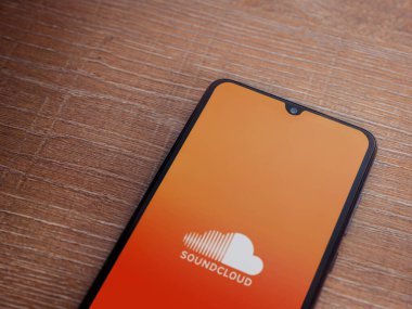 Lod, Israel - 16 Temmuz 2023: SoundCloud uygulama ekranı ahşap zemin üzerinde akıllı telefon. Üst görünüm düzlüğü kopyalama alanı ile yatıyordu.