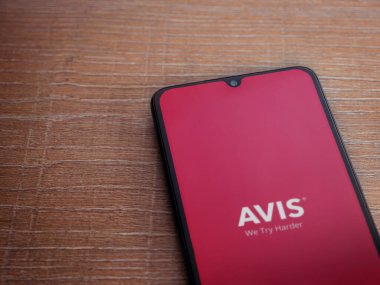 Lod, Israel - 16 Temmuz 2023: Avis IL uygulama ekranı ahşap arka planda akıllı telefon. Üst görünüm düzlüğü kopyalama alanı ile yatıyordu.