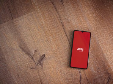 Lod, Israel - 16 Temmuz 2023: Avis IL uygulama ekranı ahşap arka planda akıllı telefon. Üst görünüm düzlüğü kopyalama alanı ile yatıyordu.