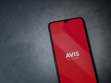 Lod, Israel - 16 Temmuz 2023: Avis IL uygulama ekranı koyu mermer mermer arka planda akıllı telefondan çalıştırılıyor. Üst görünüm düzlüğü kopyalama alanı ile yatıyordu.