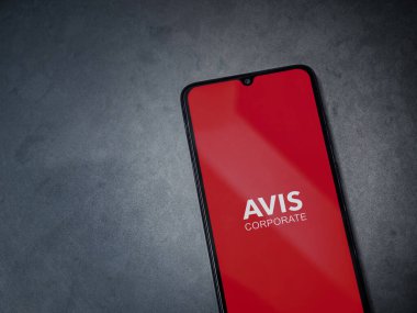 Lod, Israel - 16 Temmuz 2023: Avis Corporate uygulaması koyu mermer taşlı arka planda akıllı telefondan kalkış ekranı. Üst görünüm düzlüğü kopyalama alanı ile yatıyordu.