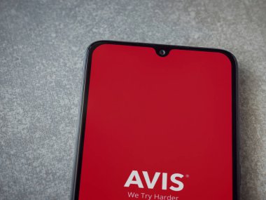 Lod, Israel - 16 Temmuz 2023: Avis IL uygulama ekranı seramik taş zemin üzerinde akıllı telefondan çalıştırılıyor. Üst görünüm düzlüğü kopyalama alanı ile yatıyordu.