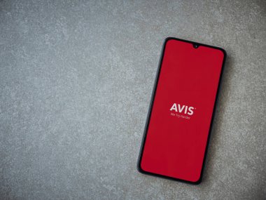 Lod, Israel - 16 Temmuz 2023: Avis IL uygulama ekranı seramik taş zemin üzerinde akıllı telefondan çalıştırılıyor. Üst görünüm düzlüğü kopyalama alanı ile yatıyordu.