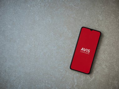 Lod, Israel - 16 Temmuz 2023: Avis Corporate uygulaması seramik taş zemin üzerinde akıllı telefon fırlatma ekranı. Üst görünüm düzlüğü kopyalama alanı ile yatıyordu.