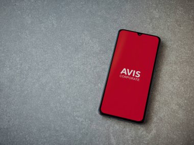 Lod, Israel - 16 Temmuz 2023: Avis Corporate uygulaması seramik taş zemin üzerinde akıllı telefon fırlatma ekranı. Üst görünüm düzlüğü kopyalama alanı ile yatıyordu.