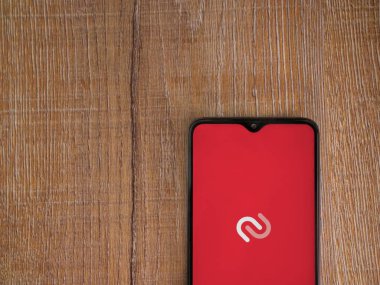 Lod, Israel - 16 Temmuz 2023: Twilio Authy Authenticator uygulama ekranı ahşap arka planda akıllı telefon. Üst görünüm düzlüğü kopyalama alanı ile yatıyordu.
