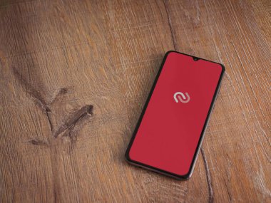 Lod, Israel - 16 Temmuz 2023: Twilio Authy Authenticator uygulama ekranı ahşap arka planda akıllı telefon. Üst görünüm düzlüğü kopyalama alanı ile yatıyordu.