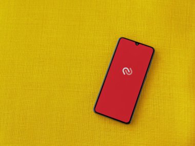 Lod, Israel - 16 Temmuz 2023: Twilio Authy Authenticator uygulama ekranı sarı kumaş zemin üzerinde akıllı telefon çalıştırma ekranı. Üst görünüm düzlüğü kopyalama alanı ile yatıyordu.