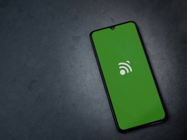 Lod, Israel - 16 Temmuz 2023: Birleşik Uzaktan Kumandalı Uygulama uygulaması koyu mermer taşlı arka planda akıllı telefondan çalıştırma ekranı. Üst görünüm düzlüğü kopyalama alanı ile yatıyordu.