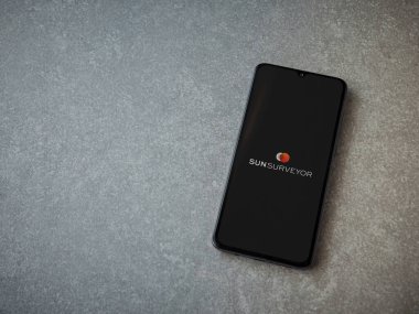 Lod, Israel - 16 Temmuz 2023: Seramik taş zemin üzerinde akıllı telefondan Sun Surveyor uygulaması fırlatma ekranı. Üst görünüm düzlüğü kopyalama alanı ile yatıyordu.