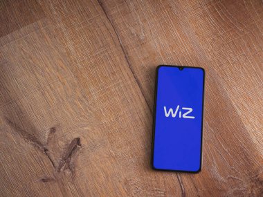 Lod, Israel - 16 Temmuz 2023: WIZ uygulama ekranı ahşap zemin üzerinde akıllı telefon. Üst görünüm düzlüğü kopyalama alanı ile yatıyordu.