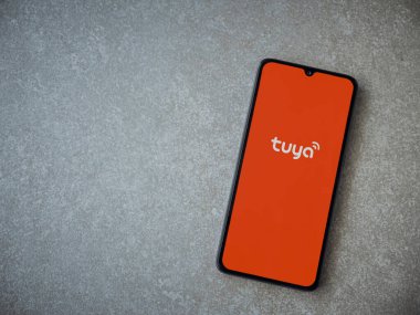 Lod, Israel - 16 Temmuz 2023: Tuya Smart uygulaması seramik taş zemin üzerinde akıllı telefondan kalkış ekranı. Üst görünüm düzlüğü kopyalama alanı ile yatıyordu.