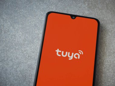 Lod, Israel - 16 Temmuz 2023: Tuya Smart uygulaması seramik taş zemin üzerinde akıllı telefondan kalkış ekranı. Üst görünüm düzlüğü kopyalama alanı ile yatıyordu.