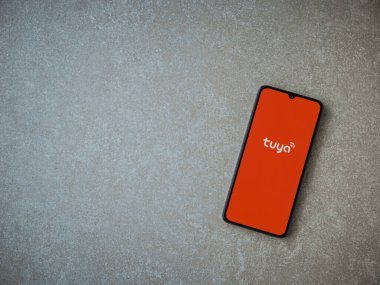 Lod, Israel - 16 Temmuz 2023: Tuya Smart uygulaması seramik taş zemin üzerinde akıllı telefondan kalkış ekranı. Üst görünüm düzlüğü kopyalama alanı ile yatıyordu.