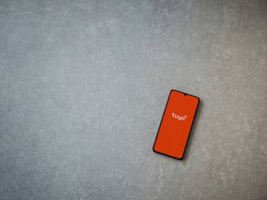 Lod, Israel - 16 Temmuz 2023: Tuya Smart uygulaması seramik taş zemin üzerinde akıllı telefondan kalkış ekranı. Üst görünüm düzlüğü kopyalama alanı ile yatıyordu.