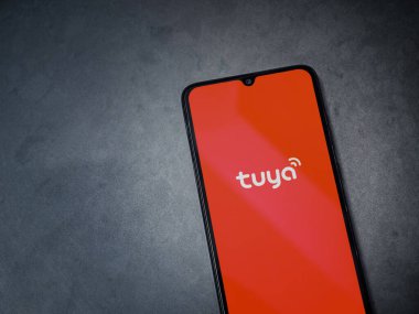 Lod, Israel - 16 Temmuz 2023: Tuya Smart uygulaması koyu mermer taşlı arka planda akıllı telefondan kalkış ekranı. Üst görünüm düzlüğü kopyalama alanı ile yatıyordu.