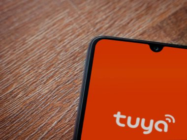 Lod, Israel - 16 Temmuz 2023: Tuya Smart uygulama ekranı ahşap arka planda akıllı telefon. Üst görünüm düzlüğü kopyalama alanı ile yatıyordu.