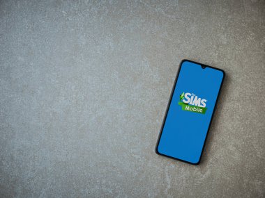 Lod, Israel - 16 Temmuz 2023: Sims Mobile uygulaması seramik taş zemin üzerinde akıllı telefon fırlatma ekranı. Üst görünüm düzlüğü kopyalama alanı ile yatıyordu.