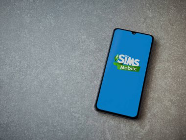 Lod, Israel - 16 Temmuz 2023: Sims Mobile uygulaması seramik taş zemin üzerinde akıllı telefon fırlatma ekranı. Üst görünüm düzlüğü kopyalama alanı ile yatıyordu.