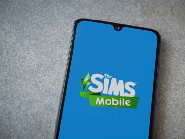 Lod, Israel - 16 Temmuz 2023: Sims Mobile uygulaması seramik taş zemin üzerinde akıllı telefon fırlatma ekranı. Üst görünüm düzlüğü kopyalama alanı ile yatıyordu.
