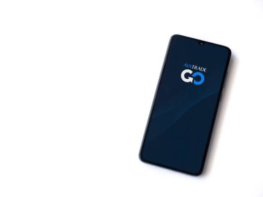 Lod, Israel - 16 Temmuz 2023: Beyaz arka planda akıllı telefondan Avatrade uygulaması fırlatma ekranı. Üst görünüm düzlüğü kopyalama alanı ile yatıyordu.