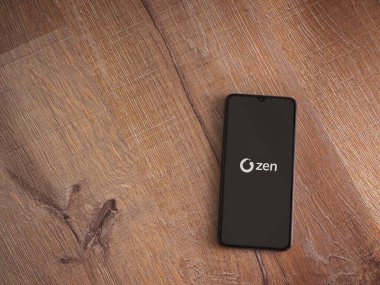 Lod, Israel - 16 Temmuz 2023: ZEN.COM uygulama ekranı ahşap zemin üzerinde akıllı telefon. Üst görünüm düzlüğü kopyalama alanı ile yatıyordu.