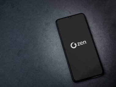 Lod, Israel - 16 Temmuz 2023: ZEN.COM uygulaması koyu mermer taşlı arka planda akıllı telefondan kalkış ekranı. Üst görünüm düzlüğü kopyalama alanı ile yatıyordu.