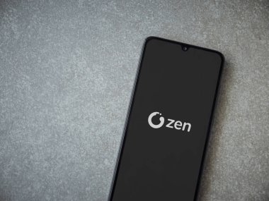 Lod, Israel - 16 Temmuz 2023: ZEN.COM uygulaması seramik taş zemin üzerinde akıllı telefondan çalıştırma ekranı. Üst görünüm düzlüğü kopyalama alanı ile yatıyordu.