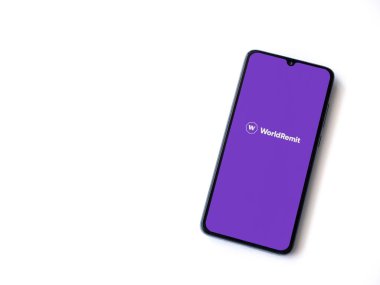 Lod, Israel - 16 Temmuz 2023: WorldRemit uygulaması beyaz arka planda akıllı telefondan çalıştırma ekranı. Üst görünüm düzlüğü kopyalama alanı ile yatıyordu.