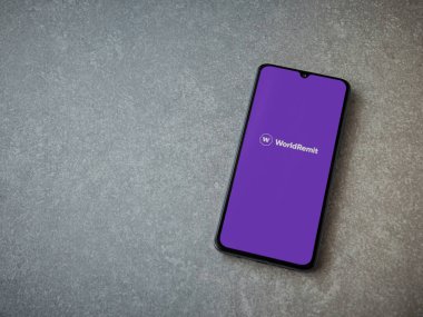 Lod, Israel - 16 Temmuz 2023: WorldRemit uygulaması seramik taş zemin üzerinde akıllı telefon fırlatma ekranı. Üst görünüm düzlüğü kopyalama alanı ile yatıyordu.