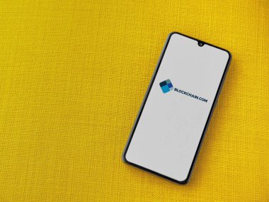 Lod, Israel - 16 Temmuz 2023: Sarı kumaş arka planda akıllı telefondan Blockchain.com uygulama başlatma ekranı. Üst görünüm düzlüğü kopyalama alanı ile yatıyordu.