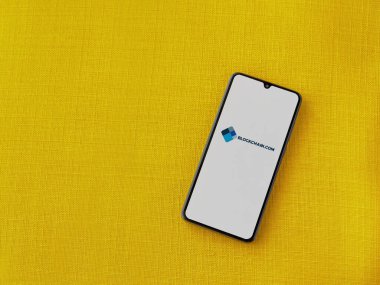 Lod, Israel - 16 Temmuz 2023: Sarı kumaş arka planda akıllı telefondan Blockchain.com uygulama başlatma ekranı. Üst görünüm düzlüğü kopyalama alanı ile yatıyordu.