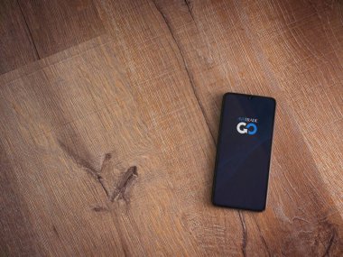 Lod, Israel - 16 Temmuz 2023: Ahşap arka planda akıllı telefondan Avatrade uygulaması fırlatma ekranı. Üst görünüm düzlüğü kopyalama alanı ile yatıyordu.