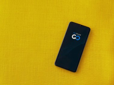 Lod, Israel - 16 Temmuz 2023: Sarı kumaş arka planda akıllı telefondan Avatrade uygulaması fırlatma ekranı. Üst görünüm düzlüğü kopyalama alanı ile yatıyordu.