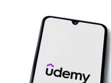 Lod, Israel - 16 Temmuz 2023: Udemy uygulaması beyaz arka planda akıllı telefondan çalıştırma ekranı. Üst görünüm düzlüğü kopyalama alanı ile yatıyordu.