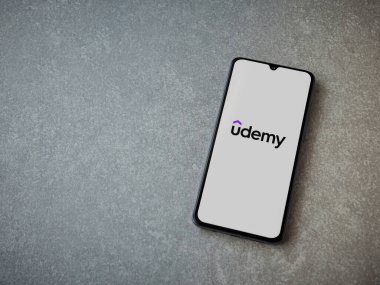 Lod, Israel - 16 Temmuz 2023: Seramik taş zemin üzerinde akıllı telefondan Udemy uygulaması fırlatma ekranı. Üst görünüm düzlüğü kopyalama alanı ile yatıyordu.