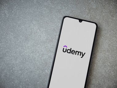 Lod, Israel - 16 Temmuz 2023: Seramik taş zemin üzerinde akıllı telefondan Udemy uygulaması fırlatma ekranı. Üst görünüm düzlüğü kopyalama alanı ile yatıyordu.