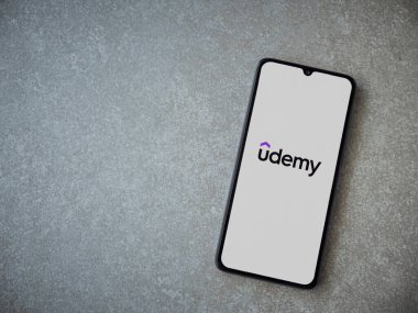 Lod, Israel - 16 Temmuz 2023: Seramik taş zemin üzerinde akıllı telefondan Udemy uygulaması fırlatma ekranı. Üst görünüm düzlüğü kopyalama alanı ile yatıyordu.