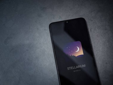 Lod, Israel - 16 Temmuz 2023: Stellarium - Koyu mermer taşlı arka planda akıllı telefondan Yıldız Haritası uygulaması fırlatma ekranı. Üst görünüm düzlüğü kopyalama alanı ile yatıyordu.