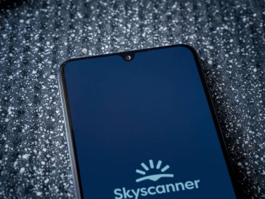 Lod, Israel - 16 Temmuz 2023: Skyscanner uygulaması metalik arkaplanda akıllı telefon fırlatma ekranı. Üst görünüm yatağını kapat.