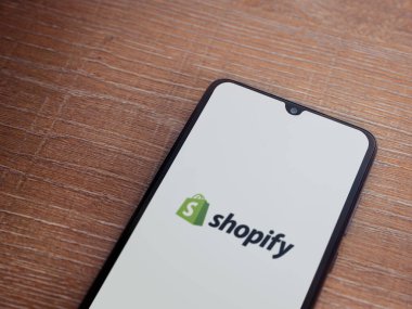 Lod, Israel - 16 Temmuz 2023: Ahşap arka planda akıllı telefondan uygulama fırlatma ekranı. Üst görünüm düzlüğü kopyalama alanı ile yatıyordu.