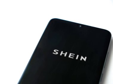 Lod, Israel - 16 Temmuz 2023: Shein uygulaması beyaz arka planda akıllı telefondan çalıştırma ekranı. Üst görünüm düzlüğü kopyalama alanı ile yatıyordu.