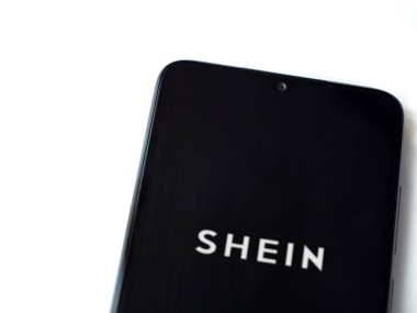 Lod, Israel - 16 Temmuz 2023: Shein uygulaması beyaz arka planda akıllı telefondan çalıştırma ekranı. Üst görünüm düzlüğü kopyalama alanı ile yatıyordu.