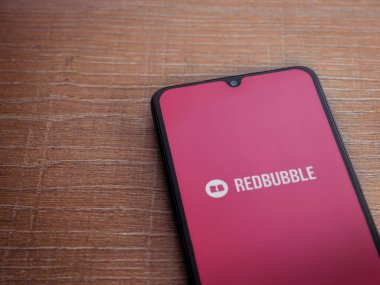 Lod, Israel - 16 Temmuz 2023: Ahşap arka planda akıllı telefondan kırmızı baloncuklu uygulama fırlatma ekranı. Üst görünüm düzlüğü kopyalama alanı ile yatıyordu.