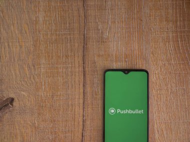 Lod, Israel - 16 Temmuz 2023: Ahşap zemin üzerinde akıllı telefon uygulaması fırlatma ekranı. Üst görünüm düzlüğü kopyalama alanı ile yatıyordu.