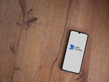 Lod, Israel - 16 Temmuz 2023: Power Automate uygulama başlatma ekranı ahşap zemin üzerinde akıllı telefon. Üst görünüm düzlüğü kopyalama alanı ile yatıyordu.