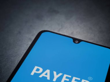 Lod, Israel - 16 Temmuz 2023: PaYEER uygulaması koyu mermer taşlı arka planda akıllı telefondan kalkış ekranı. Üst görünüm düzlüğü kopyalama alanı ile yatıyordu.