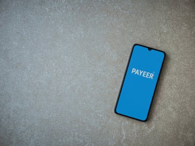 Lod, Israel - 16 Temmuz 2023: PaYEER uygulaması seramik taş zemin üzerinde akıllı telefon fırlatma ekranı. Üst görünüm düzlüğü kopyalama alanı ile yatıyordu.